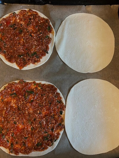 Die Pizza wird mit der Soße belegt