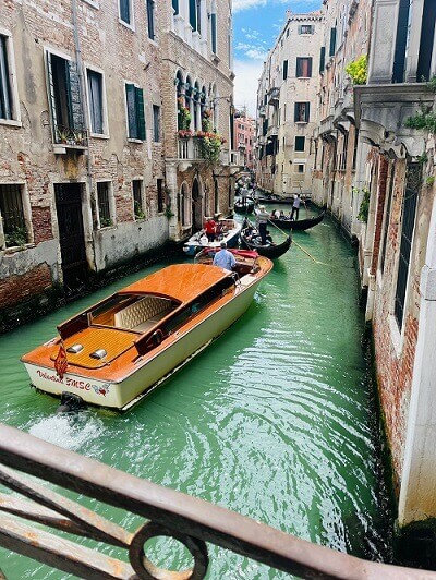 Kanal mit Boot zwischen Häusern in Venedig 