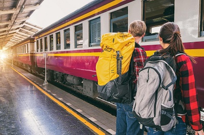 Reisende mit Rucksack am Bahnhof Reisende mit Rucksack am Bahnhof